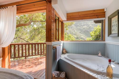 乔治Ballots Bay Treehouse by HostAgents的带浴缸的浴室和大窗户
