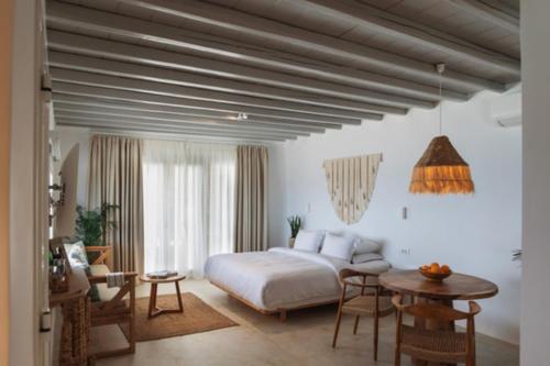圣爱奥尼斯米科诺斯Birdhouse Private Luxury Suite的卧室配有一张床和一张桌子及椅子