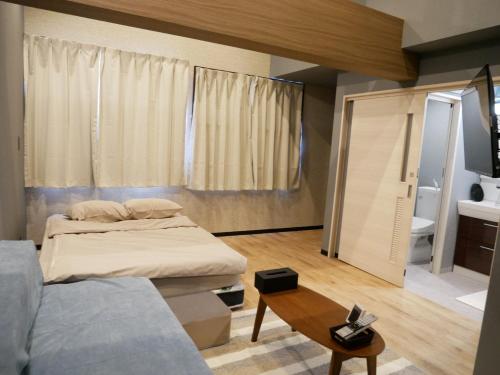 奄美HOOD - Vacation STAY 46324v的一间卧室配有一张床、一张沙发和一张桌子