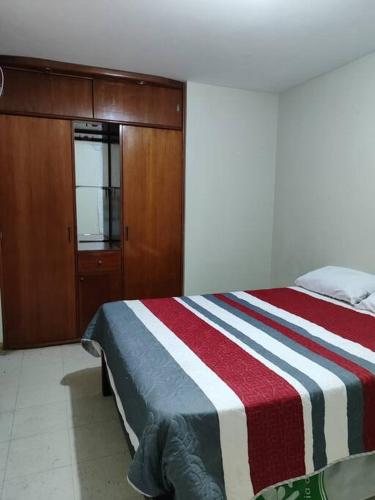 塔克纳Departamento 4 camas 3 hab的一间卧室配有一张带红白条纹毯子的床