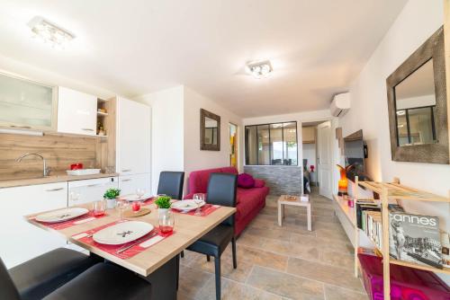La Roquette-sur-SiagneRez-de-villa climatisé, jacuzzi et piscine的一间带桌子和红色沙发的用餐室