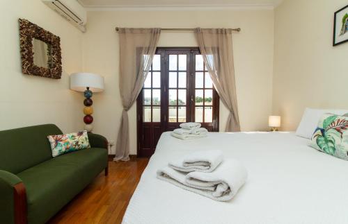 阿尔布费拉Villa a Sul的卧室配有白色的床和绿色沙发