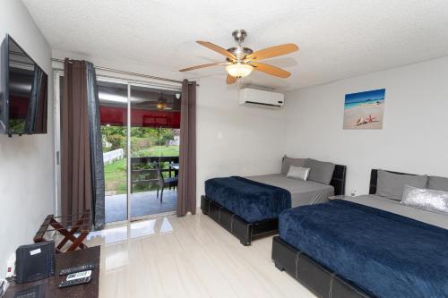 蒙特哥贝Montego Bay Club Apartments的一间卧室配有两张床和吊扇