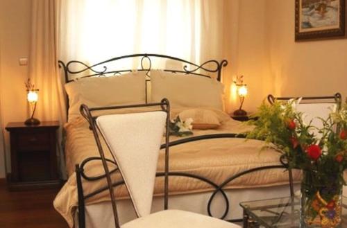 卡罗维西爱琴海酒店的一间卧室配有一张带两盏灯和鲜花的床。
