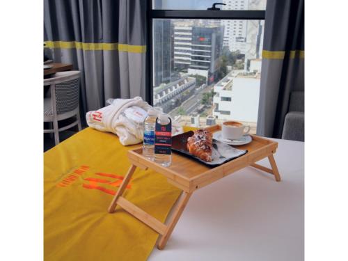 卡萨布兰卡New Hotel Piscine Wellness & Spa的一张桌子,床上放着一个食物盘,还有窗户