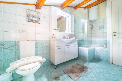科孚镇Maisonette的浴室配有卫生间、盥洗盆和浴缸。
