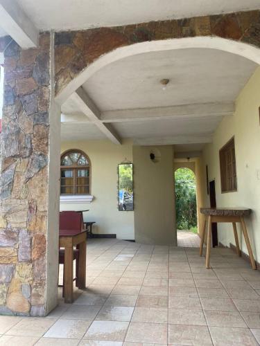 科万Hotel Xucaneb的开放式走廊设有石墙和桌子