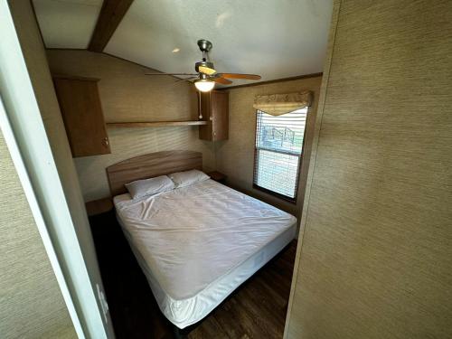 滨湖尼亚加拉Falcon Cottages的一间带一张床和吊扇的小卧室