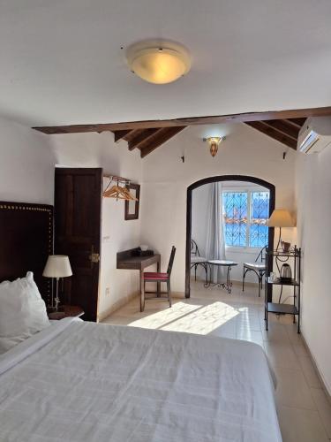 舍夫沙万达累斯萨拉姆加布里埃尔旅馆的卧室配有一张床和一张桌子及椅子