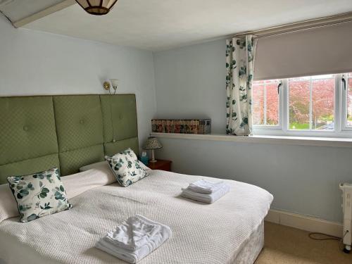 福特罗斯The Anderson的一间卧室配有一张带白色床单的床和一扇窗户。