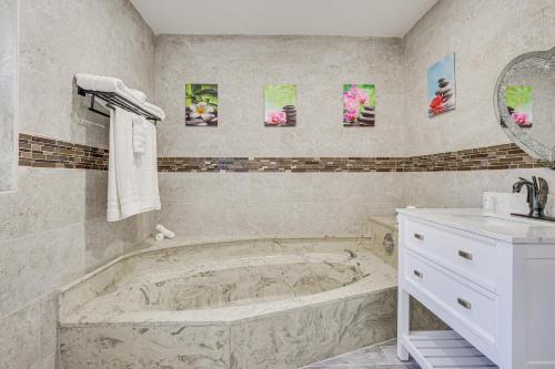 科勒尔斯普林斯Spacious Villa in Coral Springs with Pool and Hot Tub!的一间带大浴缸和水槽的浴室
