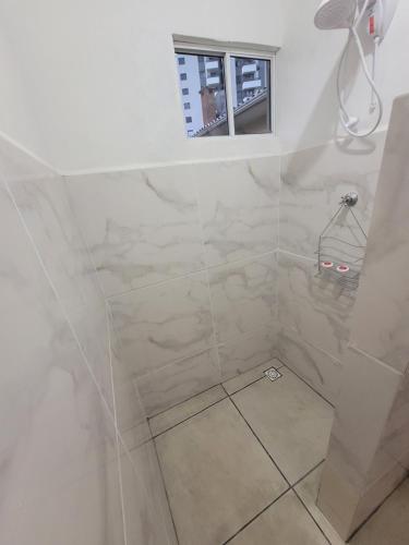 拉热斯Suíte 2 com sala的浴室设有白色瓷砖淋浴。