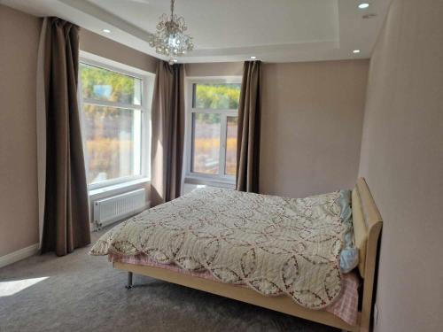 乌兰巴托Deegii's house的一间卧室设有一张床和两个窗户。