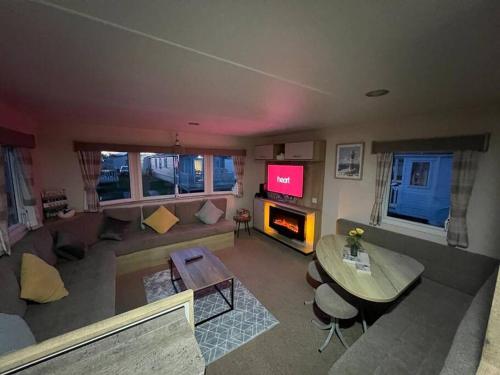 法利Primrose valley - Primrose Field 46 holiday home的客厅配有沙发和桌子