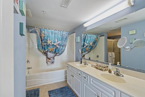 默特尔比奇Crescent Beauty的浴室设有2个水槽、浴缸和镜子