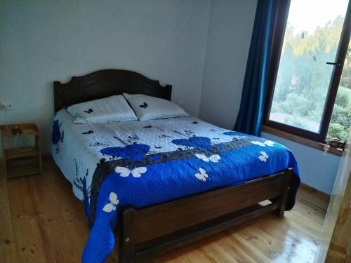 纳维达德Casa Los Queñes的一间卧室配有一张带蓝色棉被的床
