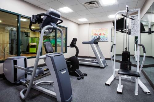 奥兰多奥兰多国际机场温盖特温德姆酒店的一间健身房,里面设有跑步机和椭圆机