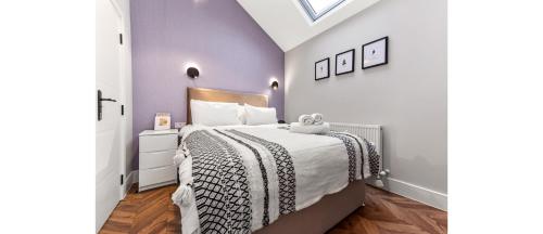 罗姆福特Cozy 1 BD Flat in London!的一间卧室配有一张带黑白色床罩的床。