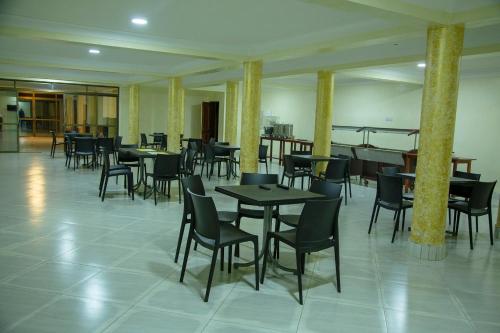 Eziana palm hotels的一间在房间内配有桌椅的餐厅