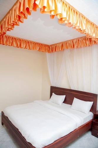 Eziana palm Hotels的一间卧室配有一张带橙色天篷的床