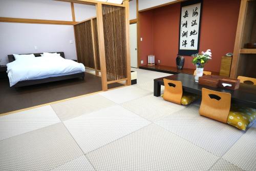 白滨白浜・温泉リゾート海岳的卧室配有一张床和一张桌子及椅子
