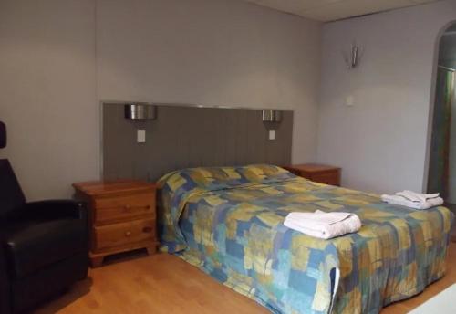 ClermontLeo Hotel Motel的一间卧室配有一张床,上面有两条毛巾