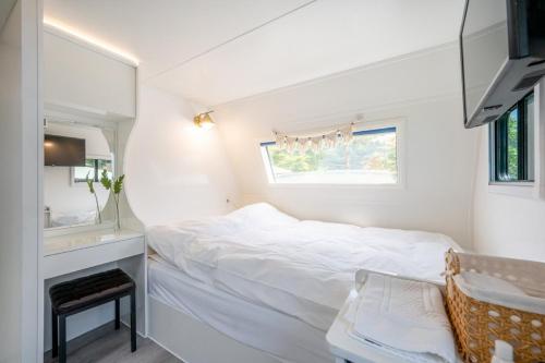 加平Gapyeong Olden Caravan & Pension - Pet Friendly的白色卧室配有床和镜子