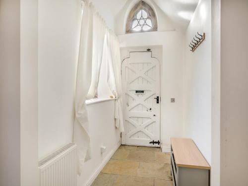 PuddletownOld School Retreat的走廊上设有白色门和桌子
