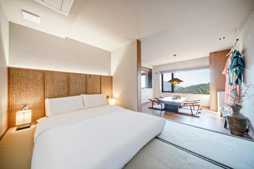 釜山Mandeok Denbasta Ryokan的一间卧室配有一张大床和一张桌子