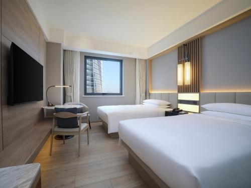 上海上海西藏大厦万怡酒店的酒店客房配有两张床和一张书桌