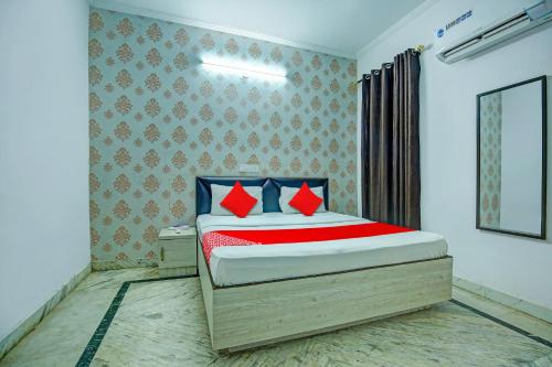 卢迪亚纳OYO HOTEL WINNER INN的一间卧室配有一张带红色和蓝色枕头的床