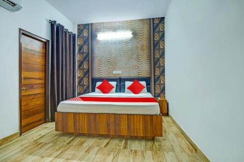 卢迪亚纳OYO HOTEL WINNER INN的一间卧室配有红色枕头的床