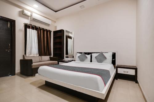 印多尔Super Townhouse1306 Hotel Prime Stay的卧室配有一张白色大床和一把椅子