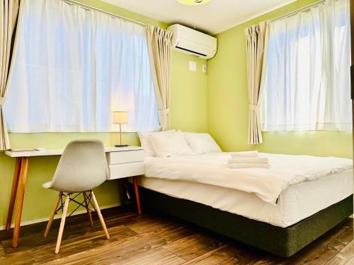 富士吉田市MEGUFUJI PLUS+的一间卧室配有一张床、一张桌子和一把椅子