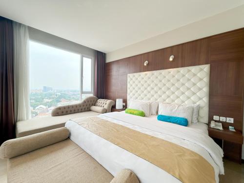 万隆格兰德泰布酒店的一间卧室设有一张大床和大窗户