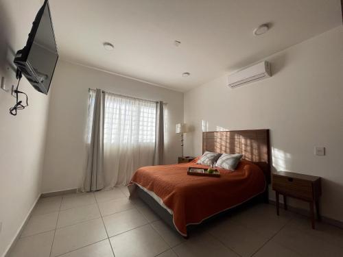 马萨特兰Departamentos DOS21的一间卧室配有带橙色床单的床和窗户。