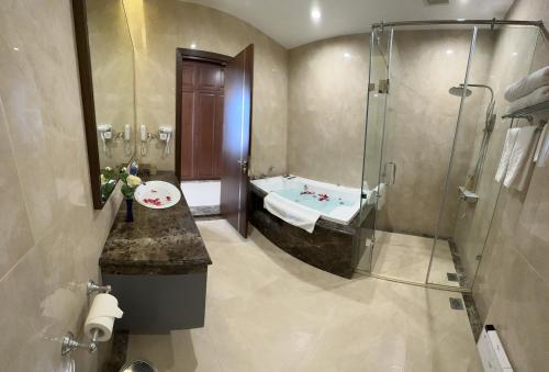 Bồ SơnKinh Bắc Palace Hotel的设有带浴缸和淋浴的浴室。