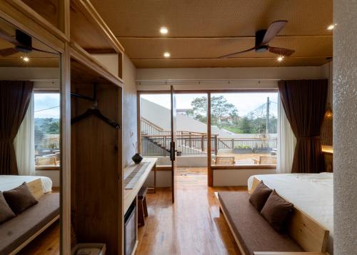 Kon Von KlaMăngDiang Boutique Hotel的一间带两张床的卧室和一个阳台