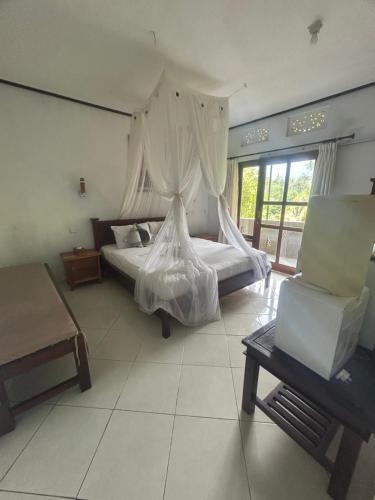 新加拉惹苏吉格德民宿的一间卧室配有一张床和一把椅子