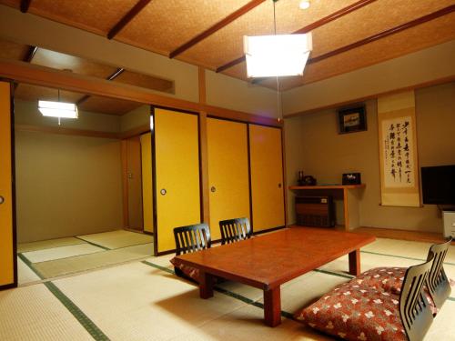 水上町Yumoto Choseikan的配有桌椅和厨房的房间