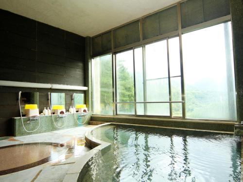 水上町Yumoto Choseikan的一间带大窗户的游泳池的浴室