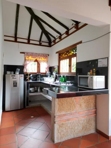 莱瓦镇Cabañas Villa Encanto的厨房配有黑色台面和电器