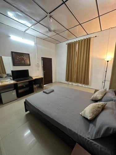 迪马普尔Premier Lodge的一间卧室配有一张大床和一张书桌