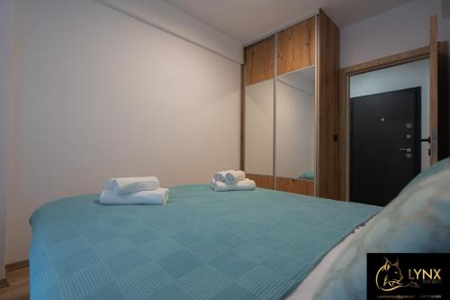 马夫罗沃Lynx Apartment的一间卧室配有蓝色的床和毛巾