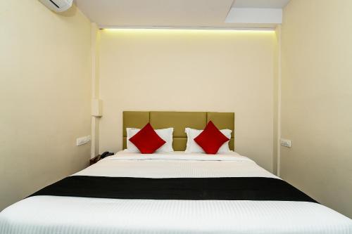 MohammadnagarSuper Capital O Hotel Siddartha Grand的一间卧室配有一张带红色枕头的大床