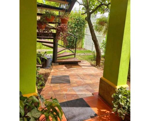 莱昂Hostal San Antonio的一个带绿色柱子和楼梯的户外庭院
