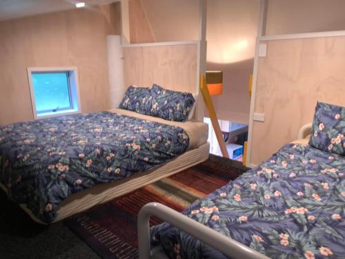Cooks BeachCountry Retreat的一间卧室设有两张床和窗户。