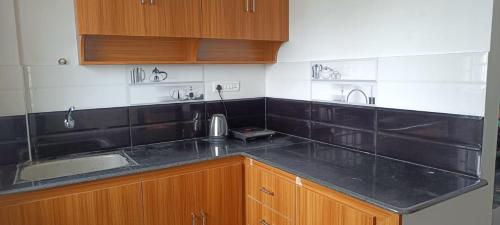 蓬蒂切里NMS GRAND VIEW TOWER的厨房配有黑色台面和水槽