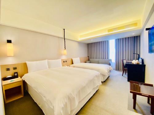 台东台东南丰铁花栈的酒店客房设有两张床和一张桌子。