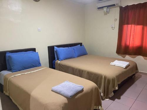 Kampong SelanchorOYO 90914 Hotel Mei Wah的配有蓝色枕头的客房内的两张床